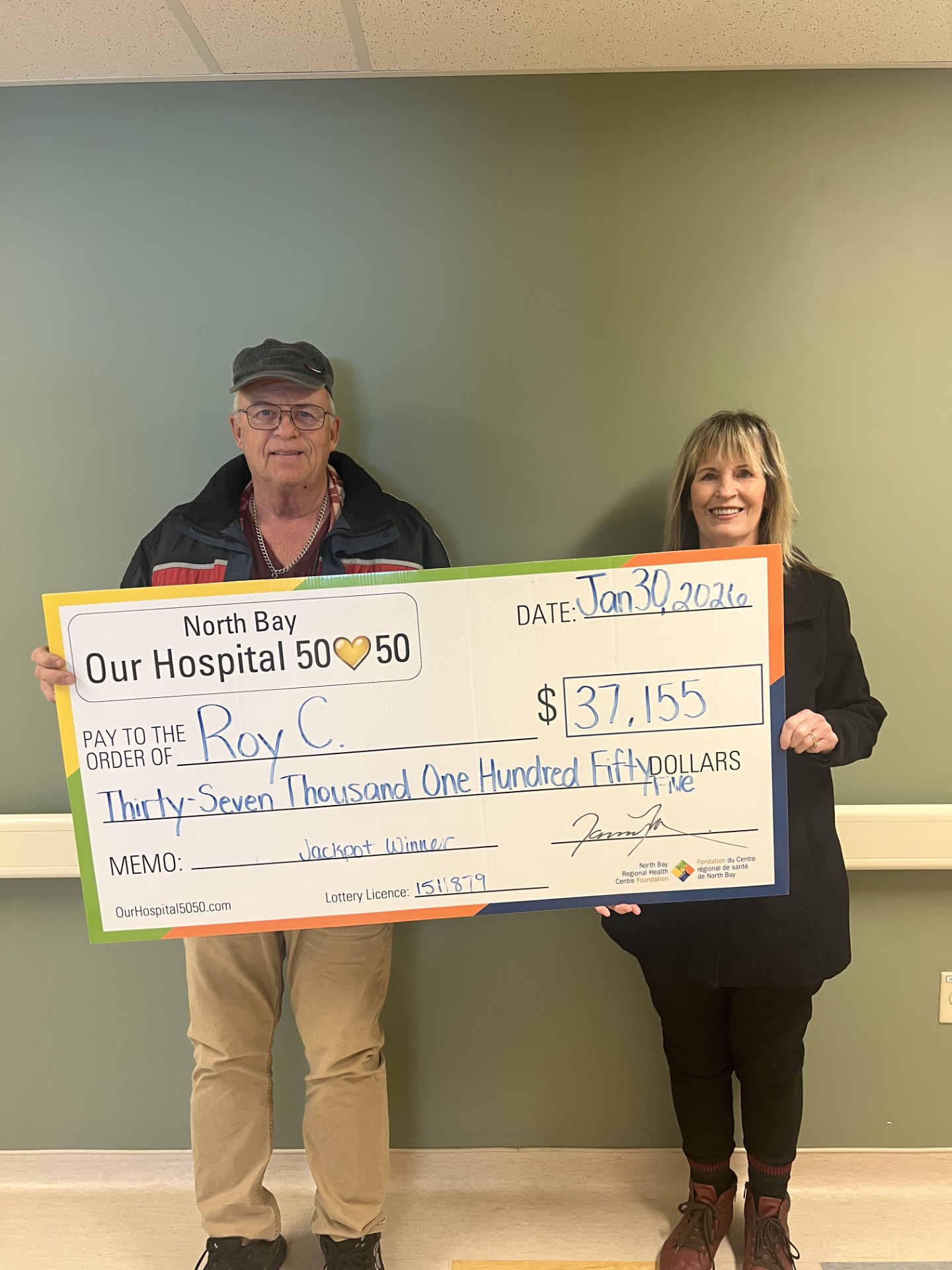 50/50 Winner Grant Matton standing with NBRHC Foundation Employee with oversized cheque. The cheque is for $66,242.