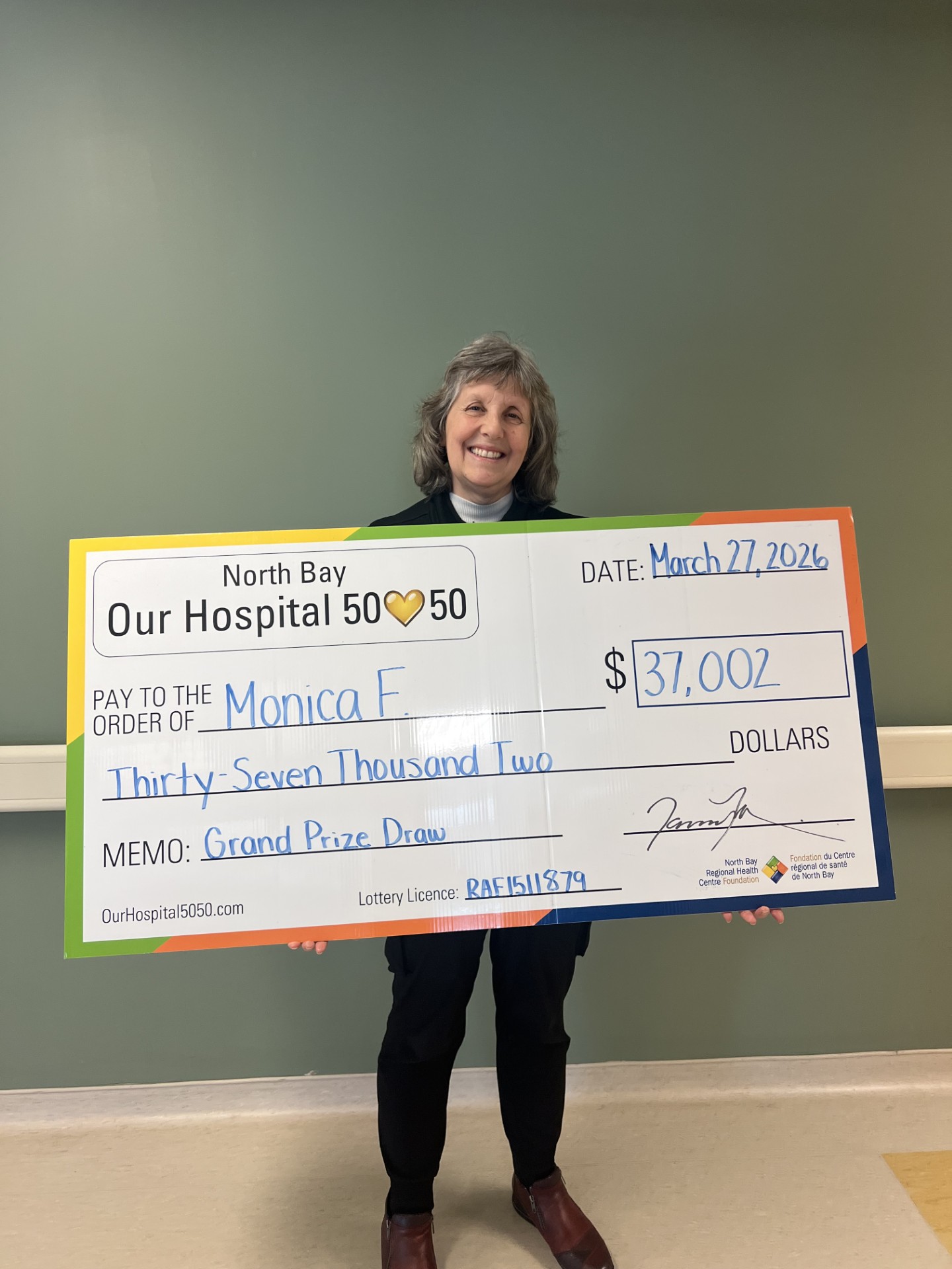 50/50 Winner Grant Matton standing with NBRHC Foundation Employee with oversized cheque. The cheque is for $66,242.