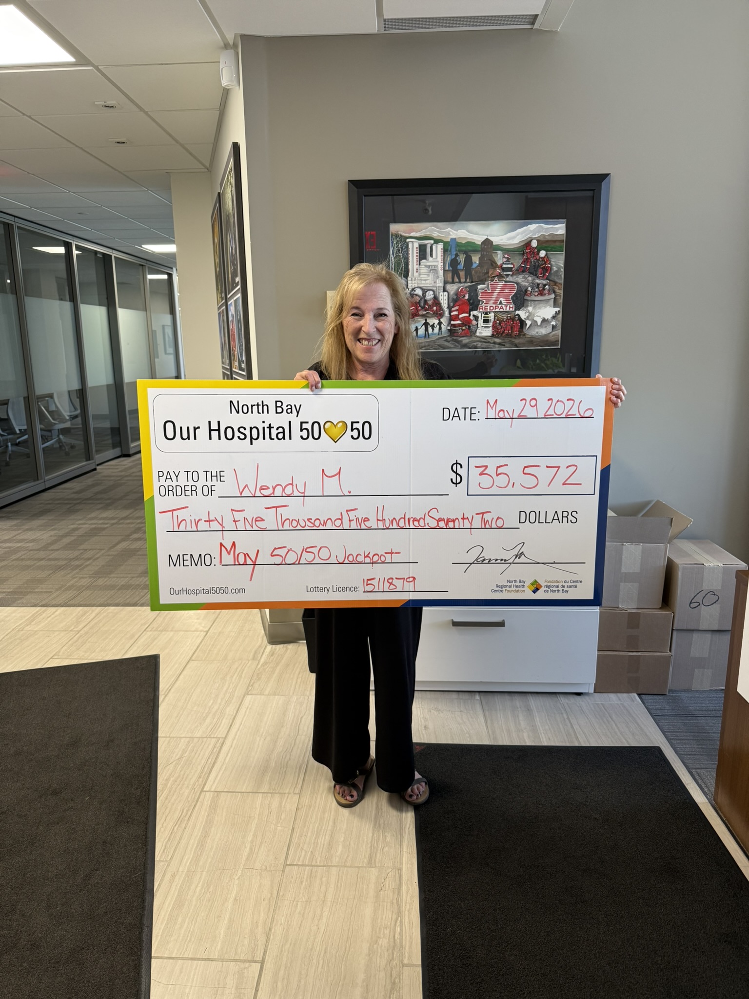 50/50 Winner Grant Matton standing with NBRHC Foundation Employee with oversized cheque. The cheque is for $66,242.