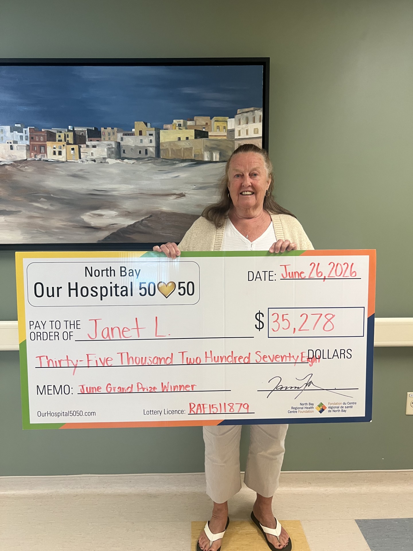 50/50 Winner Grant Matton standing with NBRHC Foundation Employee with oversized cheque. The cheque is for $66,242.