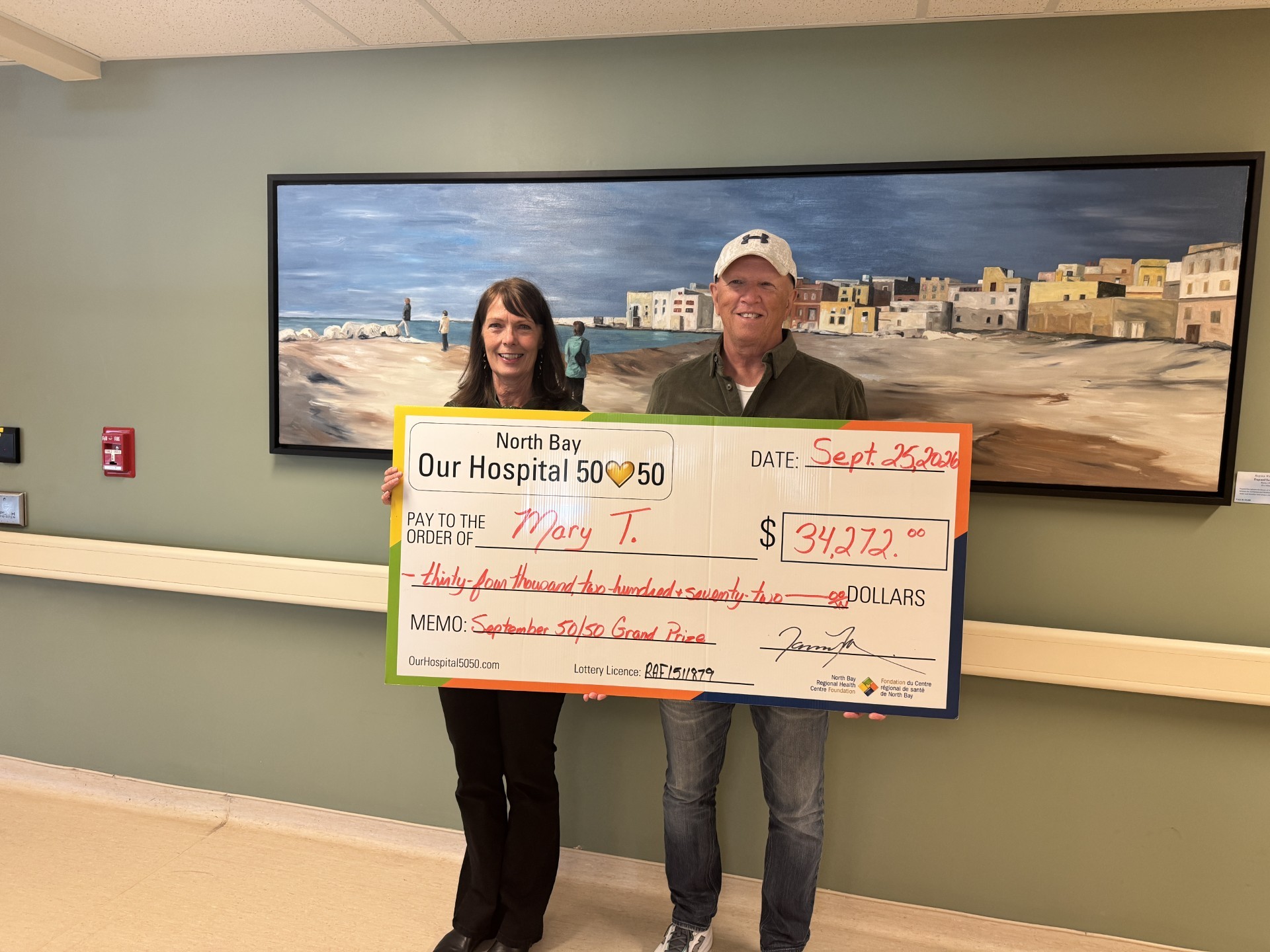 50/50 Winner Grant Matton standing with NBRHC Foundation Employee with oversized cheque. The cheque is for $66,242.