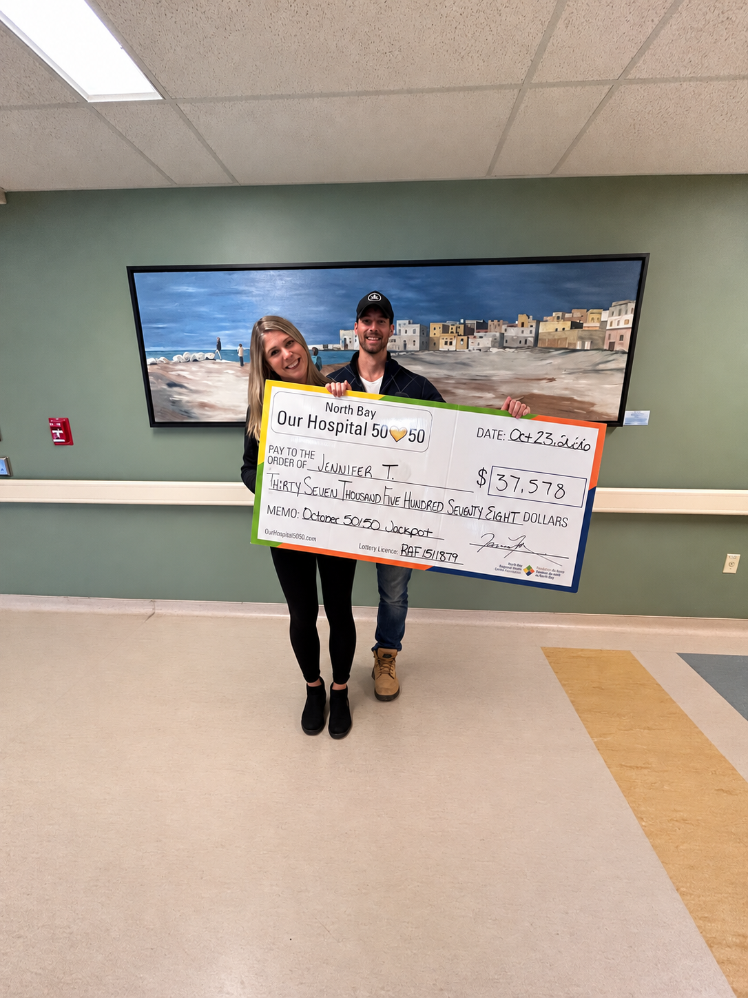 50/50 Winner Grant Matton standing with NBRHC Foundation Employee with oversized cheque. The cheque is for $66,242.